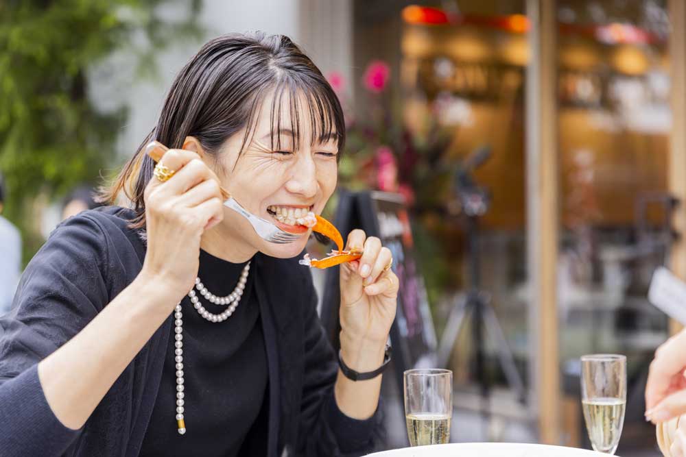 ロブスターをおいしそうに頬張る女性